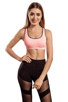 Beautiful young woman in sportswear standing on a white isolated background. Tightened, thin body. Fitness model. Pose.