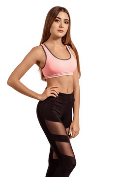 Beautiful young woman in sportswear standing on a white isolated background. Tightened, thin body. Fitness model. Pose.