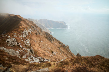 vista del paso de un solo hombre, costa montañosa, comienzo de una reja, alambrado rustico en el...