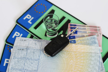 Polskie dokumenty samochodu, prawo jazdy, kluczyk, dowód rejestracyjny, tablice rejestracyjne i alkohol.