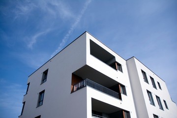 Exterior of new apartment buildings on a blue cloudy sky background. No people. Real estate business concept.