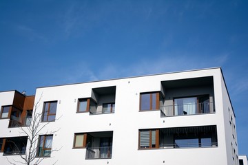 Exterior of new apartment buildings on a blue cloudy sky background. No people. Real estate business concept.