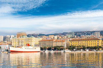 Fototapeta premium Croatia, city of Rijeka, view of harbor, seascape and skyline of the city center and old port cranes, blue sky with clouds 