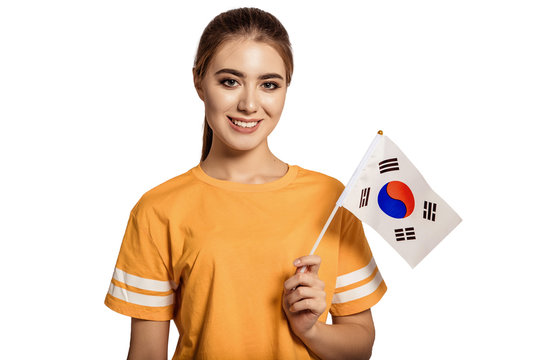 A beautiful young woman holds in her hands the flag of Korea. Exchange student, learn language. Tourist traveling. White background. Isolate. Football fan.