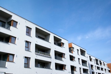 Exterior of new apartment buildings on a blue cloudy sky background. No people. Real estate business concept.