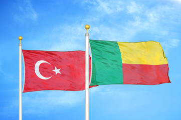 Turkey and Benin two flags on flagpoles and blue cloudy sky