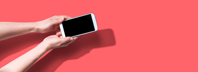 Person using a white smartphone from above