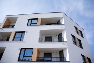 Exterior of new apartment buildings on a blue cloudy sky background. No people. Real estate business concept.