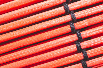 Bamboo mat background close up. wooden backdrop. red wooden sticks tied together