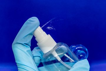 Spray disinfect liquid, hand in blue glove on blue