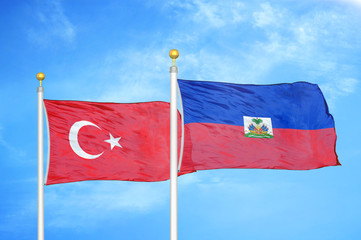 Turkey and Haiti two flags on flagpoles and blue cloudy sky