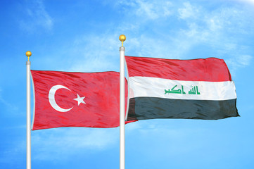 Turkey and Iraq two flags on flagpoles and blue cloudy sky