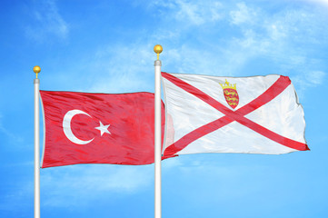 Turkey and Jersey two flags on flagpoles and blue cloudy sky