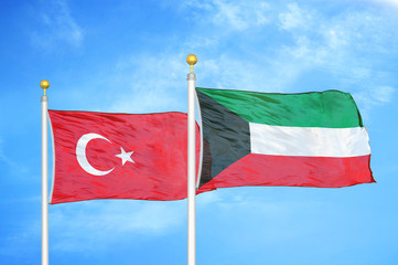 Fototapeta na wymiar Turkey and Kuwait two flags on flagpoles and blue cloudy sky