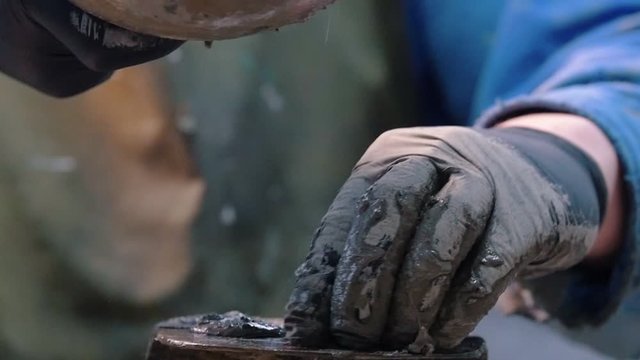 Concrete workshop - a man in a blue suit smearing concrete in shape