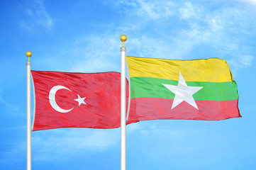 Turkey and Myanmar two flags on flagpoles and blue cloudy sky