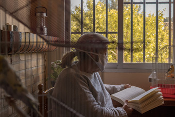 Mujer pasando la cuarentena mientras lee un libro