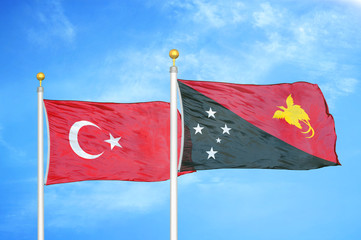 Turkey and Papua New Guinea two flags on flagpoles and blue cloudy sky