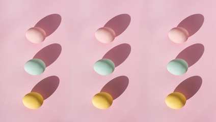 trendy easter background pattern. Modern beautiful egg coloring different Candy colors blue pink yellow.   Minimalism shadow fashion banner for holiday top view flatlay copyspace place for text