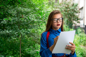 Fototapeta premium The young writer looking for inspiration for a walk. Stylish girl with leaves in their hands.