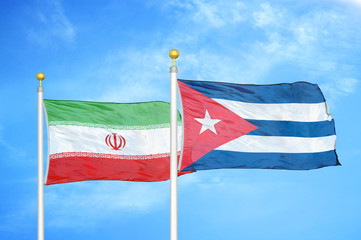 Iran and Cuba two flags on flagpoles and blue cloudy sky