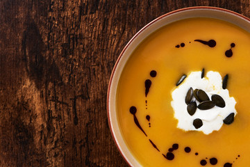 Pumpkin creme soup with pumpkin seeds, oil and whipped cream