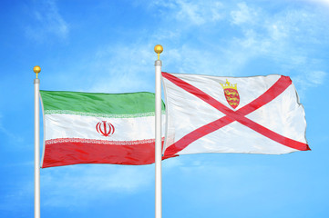 Iran and Jersey two flags on flagpoles and blue cloudy sky