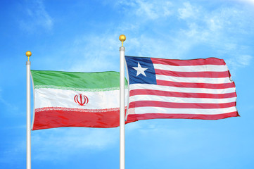 Fototapeta premium Iran and Liberia two flags on flagpoles and blue cloudy sky