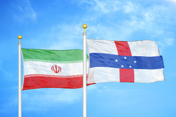 Iran and Netherlands Antilles two flags on flagpoles and blue cloudy sky