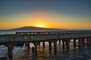 Fototapeta na wymiar Sunset at Mal Pier towards the ocean and Lanai.