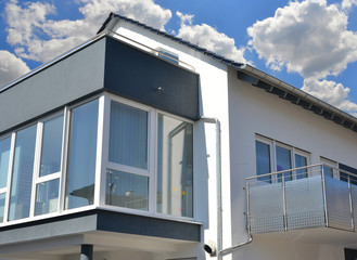 Vorgebaute hängende Wintergarten-Balkon-Dachterrassen-Kombination mit dreiseitiger Verglasung an einem neu gebauten Wohnhaus