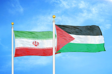 Iran and Palestine two flags on flagpoles and blue cloudy sky