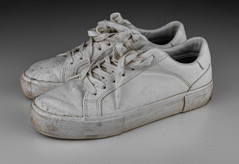 Dirty, used, muddy white dirty pair of shoes on white dirty floor © ozencdeniz