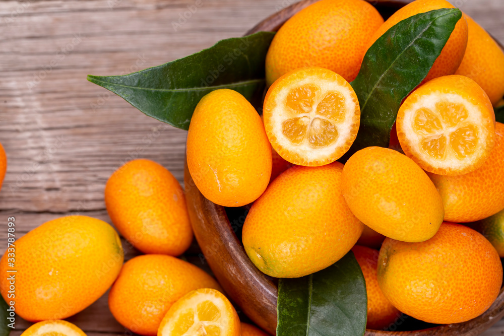 Wall mural Top view of bunch of fresh kumquats in the organic food market. Some kumquats is cutted.