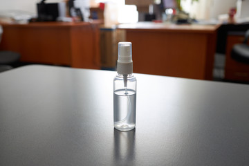 hand sanitizer at office workplace on a wooden table background.