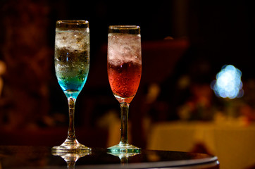 Dos copas de champán de colores azul y rojo