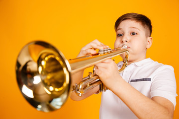 A cheerful boy plays the pipe blowing his cheeks. Humor playing a wind instrument © Yauhen