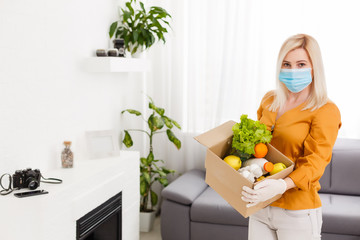Obraz na płótnie Canvas Delivery girl wears medical face mask and gloves and holds box close-up portrait. Concept of safe services during covid-19 outbreak. Courier