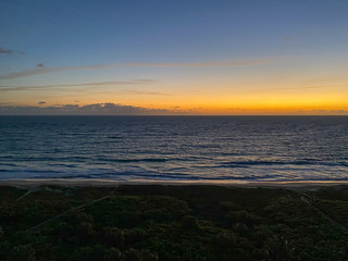 An aerial view of the sunrise over the Atlantic Ocean with palm trees on a  beautiful morning