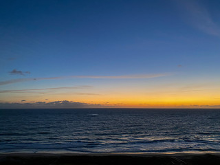 An aerial view of the sunrise over the Atlantic Ocean with palm trees on a  beautiful morning
