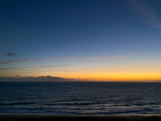 Naklejka premium An aerial view of the sunrise over the Atlantic Ocean with palm trees on a beautiful morning