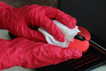 Disinfection of your workspace, the fight against the virus, coronavirus COVID-19. A female hand wipes a computer mouse disinfecting wipes.