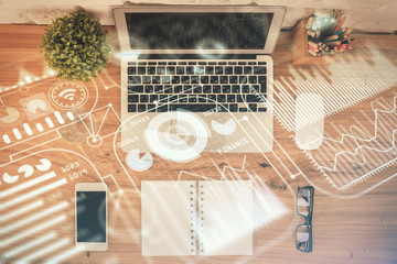 Technology hologram drawing over computer on the desktop background. Top view. Double exposure. Tech concept.