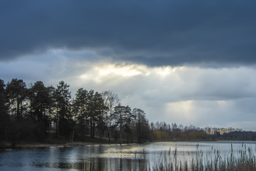 Evening natural landscape, dark forest and forest lake at sunset