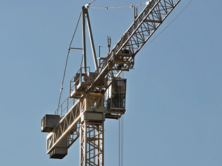 Fototapeta premium Tower cranes work during the construction of a multi-story building. New apartments for residents and premises for offices. Risky work at height. Lifting heavy building materials. City development
