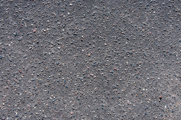 Texture of black asphalt, bitumen and stones, small inclusions.