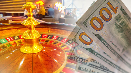 Roulette. Hundred dollar bills on the background of the casino hall. Roulette table drum closeup. Concept - spending money on a casino. Concept - search for fortune. Sale of casino equipment.