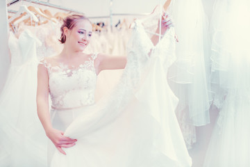 Young woman shopping in wedding shop for a dress to wear