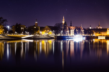 Fototapeta na wymiar Panoramic view of Night Wroclaw City, Odra river and reflections of historical buildings in it.