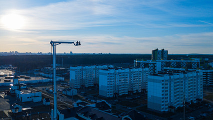 Fototapeta premium Fire department truck ladder extended on classic blue sky and panoramic view of city background. Aerial view.